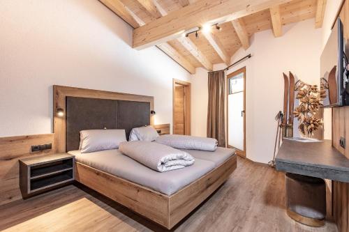 a bedroom with a large bed with a wooden headboard at Landhaus Sonnenwiese in Sölden