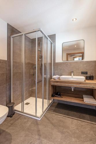 a bathroom with a shower and a sink and a tub at Landhaus Sonnenwiese in Sölden