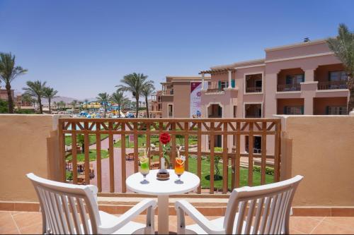 a table and chairs on a balcony with drinks at Charmillion Club Aquapark in Sharm El Sheikh