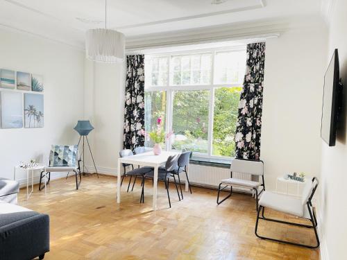 a living room with a table and chairs and a window at aday - Aalborg mansion - Big apartment with garden in Aalborg