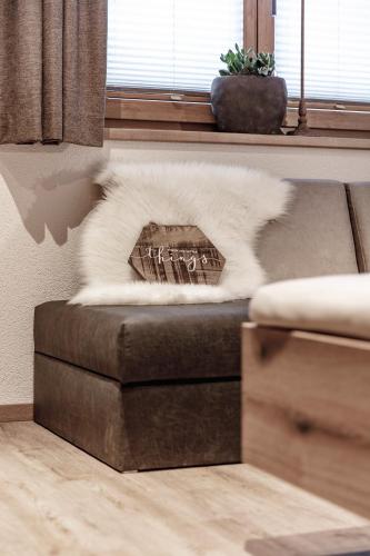 a couch with a white blanket on top of it at Landhaus Sonnenwiese in Sölden