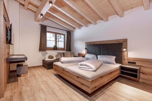 a bedroom with a large bed and a desk at Landhaus Sonnenwiese in Sölden