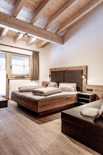 a bedroom with two beds and a wooden ceiling at Landhaus Sonnenwiese in Sölden
