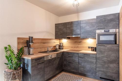 a kitchen with wooden cabinets and stainless steel appliances at Landhaus Sonnenwiese in Sölden
