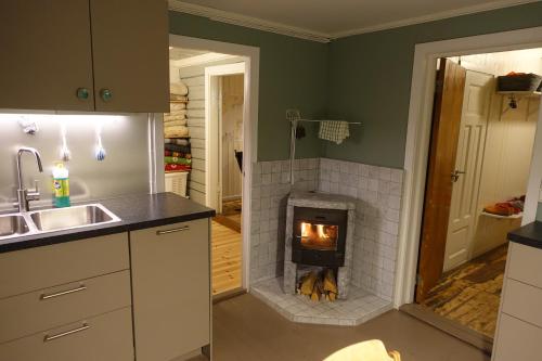 a kitchen with a brick fireplace in a room at Most photographed house in Reine in Reine