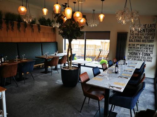 The Balerno Inn في إدنبرة: مطعم به طاولات وكراسي ومصنع الفخار