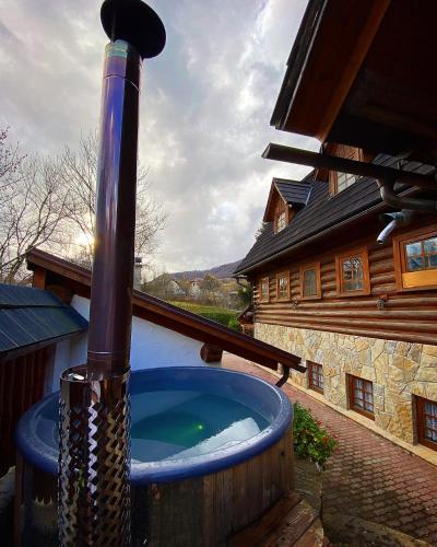a large jacuzzi tub in a yard next to a house at Jánošíkova Valaška Hills Apartments in Terchová