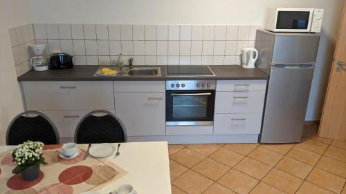 a kitchen with a stove and a refrigerator and a table at Residenzpark Willingen Typ C in Willingen
