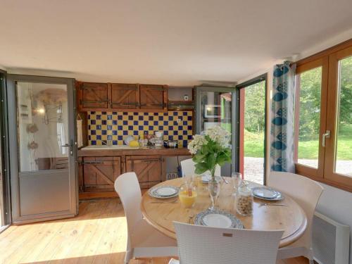 a kitchen with a wooden table with chairs and a dining room at Holiday village in Réclinghem