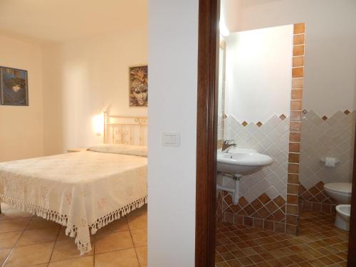 1 dormitorio con cama, lavabo y aseo en Residenza Sarra di Entu, en Cannigione