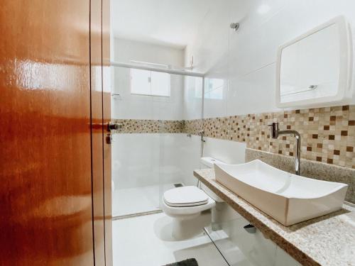 uma casa de banho com um WC, um lavatório e um chuveiro em Hotel APART Zuccolotto 301 em Aracruz