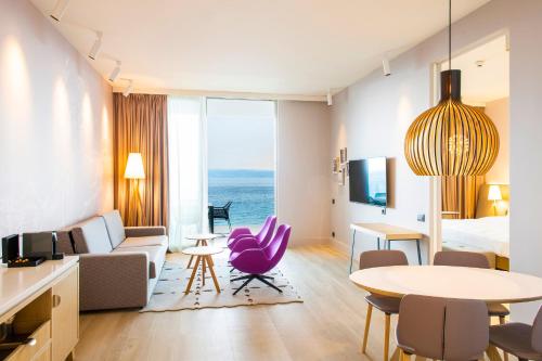 a hotel room with a purple chair and a living room at Radisson Blu Resort & Spa in Split