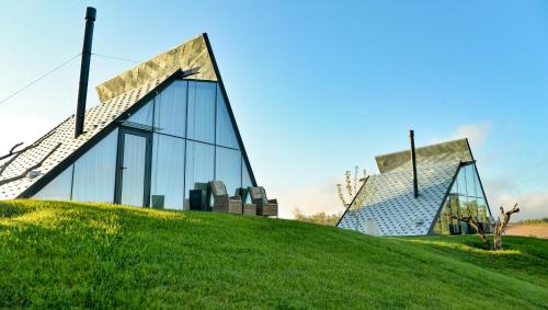 a building on top of a grassy hill at 3 Hills Boutique - The Ranch Experience in Trílofos