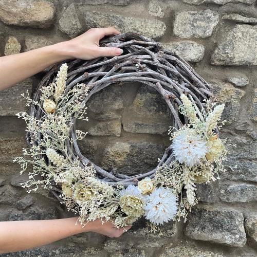 a hand holding a wreath with flowers on a brick wall at Boutique hotel Soukeníkův dům in Kutná Hora