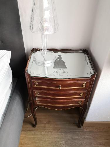 a dresser with a glass top with a lamp on top at Casa del Conte Massimiliano Roero in Cuneo