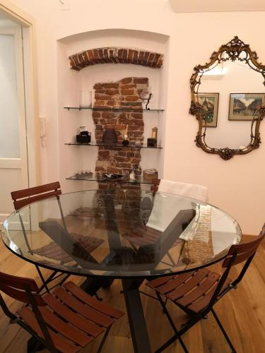 a glass table in a room with two chairs at Casa del Conte Massimiliano Roero in Cuneo