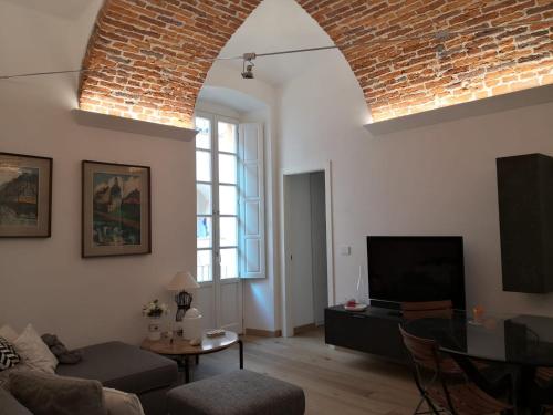 a living room with a couch and a tv at Casa del Conte Massimiliano Roero in Cuneo