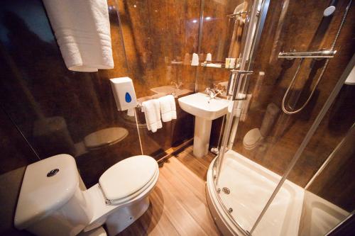 a bathroom with a toilet and a shower and a sink at Ville Hotel in Manchester