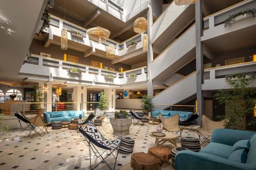 - un hall avec des canapés bleus, des chaises et des tables dans l'établissement Sunny Krk by Valamar, à Krk