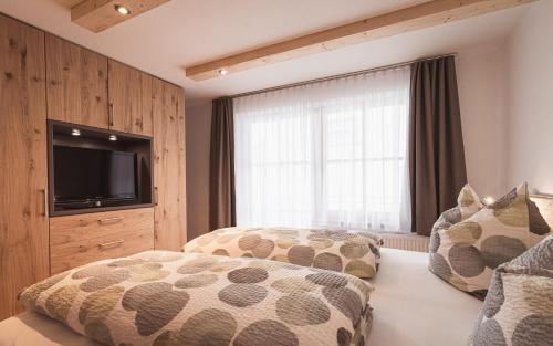 1 dormitorio con 2 camas y TV de pantalla plana en Fewo Stork, en Rettenberg