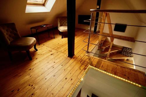 a living room with a wooden floor and a stair case at Fewo Kleine Münzenstraße 19 in Brandenburg an der Havel
