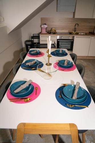 a white table with blue plates and napkins on it at Apartment VAZATAOR with sauna in Brežice