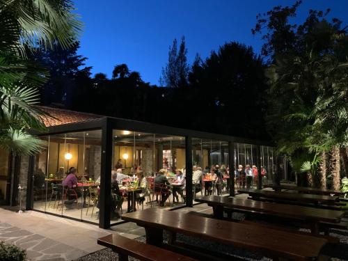 a group of people sitting at tables in a restaurant at Continental Parkhotel in Lugano