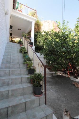 a staircase leading to a building with potted plants at Au pied de la falaise rouge in Leonidion