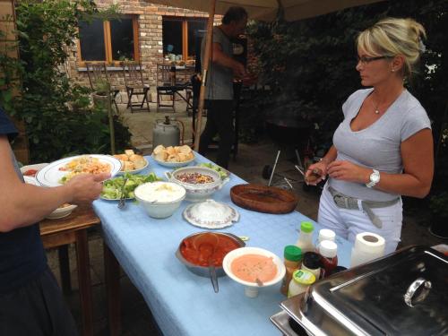 a woman standing in front of a table with food at B&B De Henehoeve in Heks