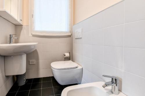 a white bathroom with a toilet and a sink at Villette Dolci Luxury Homes in Peschiera del Garda