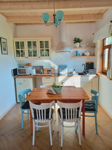 a kitchen with a wooden table and chairs at Gazdówka - najlepsza miejscówka domek w Pieninach in Krościenko