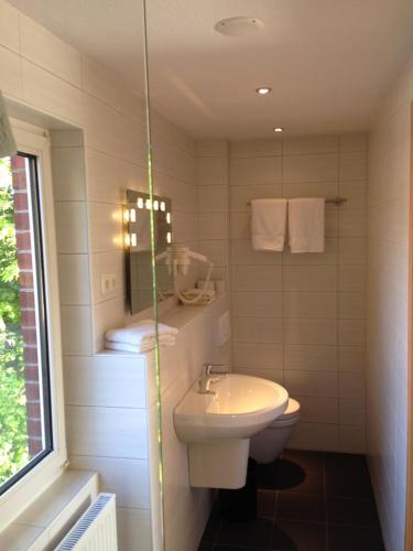 a bathroom with a white toilet and a sink at Neumanns Waldschänke in Soltau