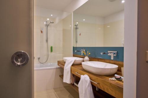 a bathroom with a sink and a tub and a shower at Henriette Stadthotel Vienna in Vienna