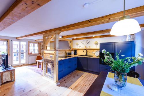 a kitchen with blue cabinets and a wooden ceiling at Kramerstube in Quedlinburg