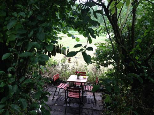 a table and chairs in a garden with trees at B&B De Henehoeve in Heks
