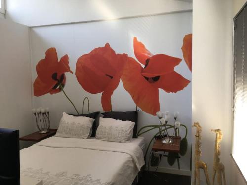 - une chambre avec un lit orné de fleurs rouges sur le mur dans l'établissement modern genieten in oud binnenstadspand, à Amersfoort