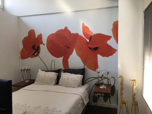 een slaapkamer met een bed met rode bloemen aan de muur bij modern genieten in oud binnenstadspand in Amersfoort