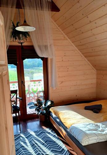 a bedroom with a bed and a large window at Gazdówka - najlepsza miejscówka domek w Pieninach in Krościenko