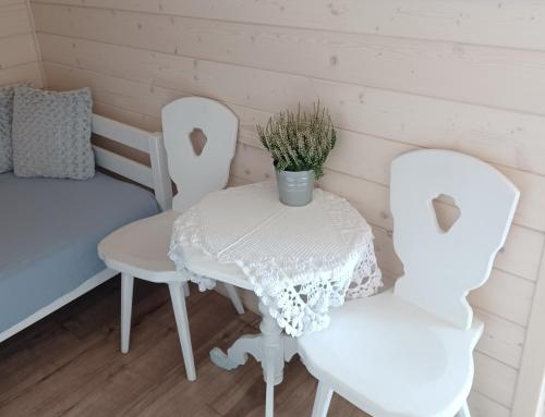 a table and two chairs and a bed in a room at Gazdówka - najlepsza miejscówka domek w Pieninach in Krościenko