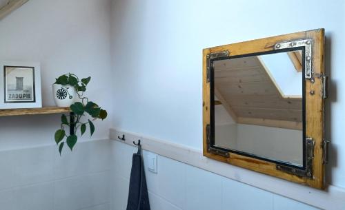 a mirror with a wooden frame on a white wall at Gazdówka - najlepsza miejscówka domek w Pieninach in Krościenko