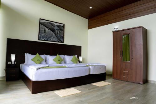 a bedroom with a large bed with a wooden headboard at Nelinsa Resort and Spa in Matale