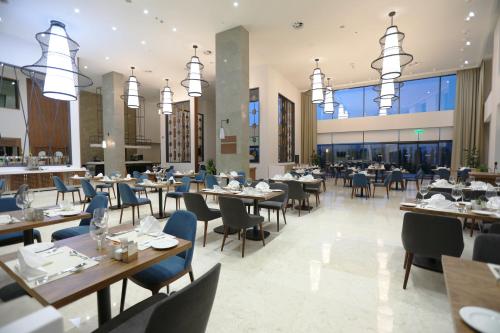 阿德亚曼Park Dedeman Adıyaman Hotel的建筑物内有桌椅的餐厅