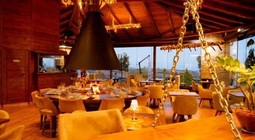 a restaurant with tables and chairs and a chandelier at 3 Hills Boutique - The Ranch Experience in Trílofos