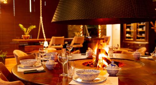 a table with a fireplace in a dining room at 3 Hills Boutique - The Ranch Experience in Trílofos