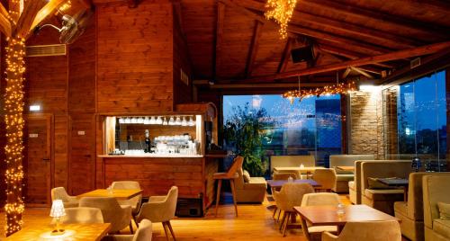 a restaurant with tables and chairs and a bar at 3 Hills Boutique - The Ranch Experience in Trílofos