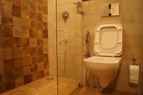uma casa de banho com um WC e uma cabina de duche em vidro. em Sharayu One em Mapuçá