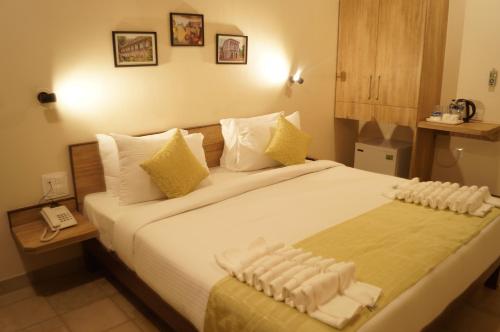 um quarto de hotel com uma cama grande com toalhas em Sharayu One em Mapuçá