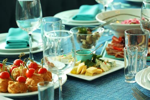 a blue table with plates of food and wine glasses at Biruza Club in Svyatopetrivske