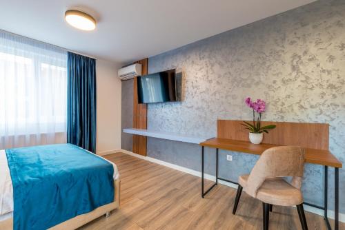 a bedroom with a desk and a bed and a table at SarmiHouse in Cluj-Napoca