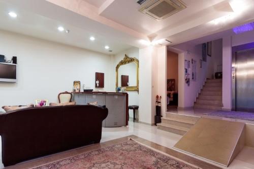 a living room with a couch and a mirror at Christina Hotel in Olympiaki Akti
